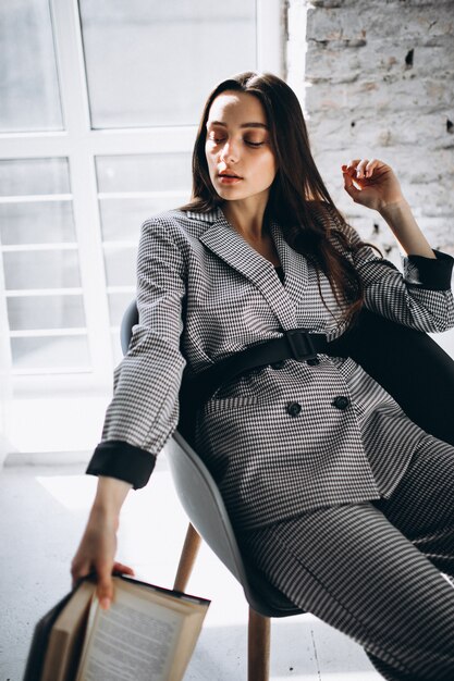 Beautiful woman in a business suit sitting in chair