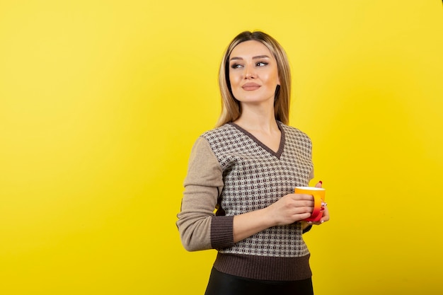 Beautiful woman in casual outfit holding cup of tea. 