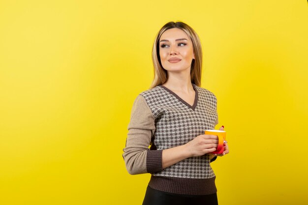 お茶を持ってカジュアルな服装の美しい女性。