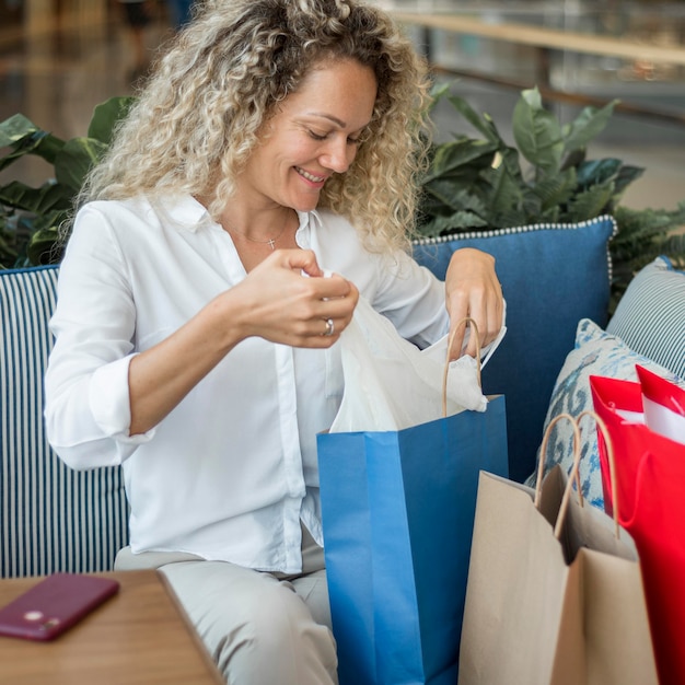 Free photo beautiful woman checking shopping bags