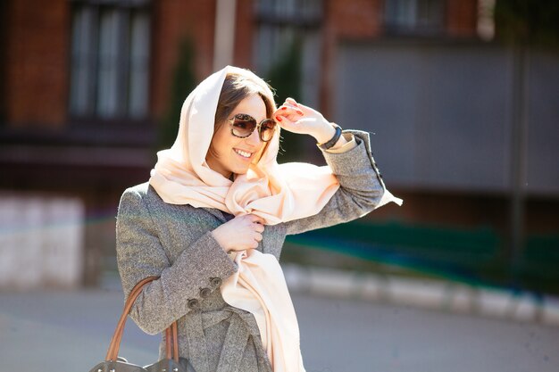 Beautiful woman in a coat posing on the street
