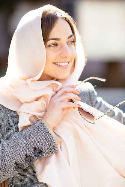 Beautiful woman in a coat posing on the street