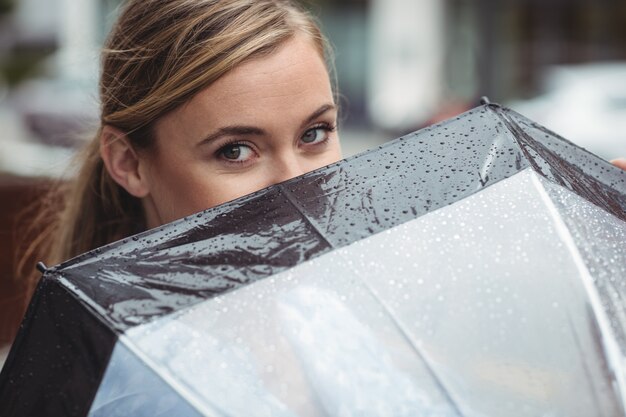 Beautiful woman covering her face with umbrella