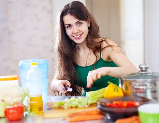 beautiful woman cuts green celery