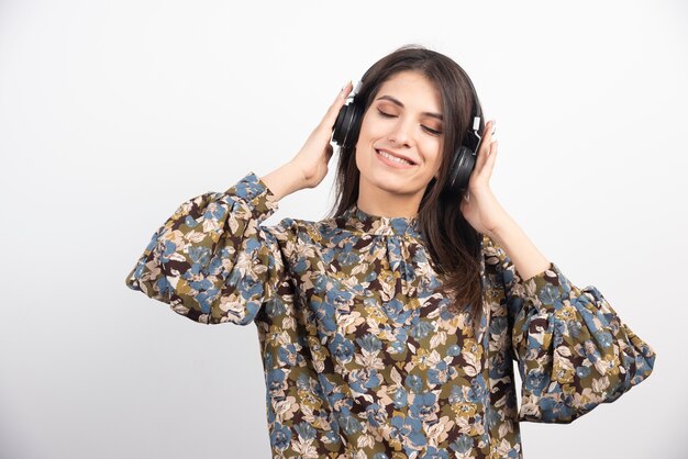 Beautiful woman dancing to the rythm on white background. 