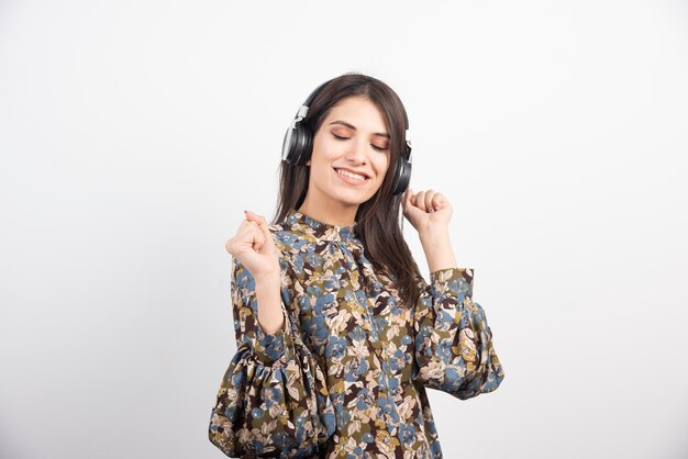 Beautiful woman dancing to the rythm on white background. 