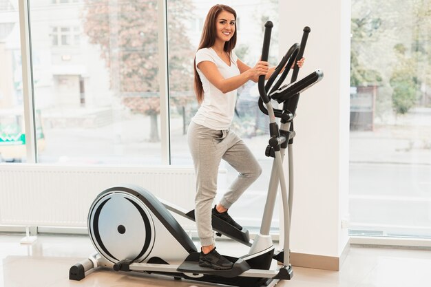 Beautiful woman doing medical exercises on stepper