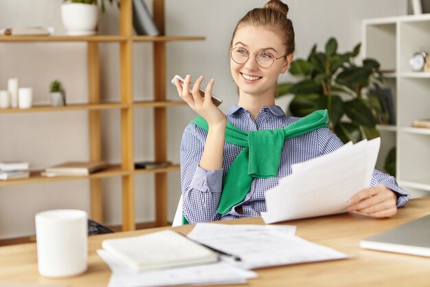 Beautiful woman dressed formally in office with phone