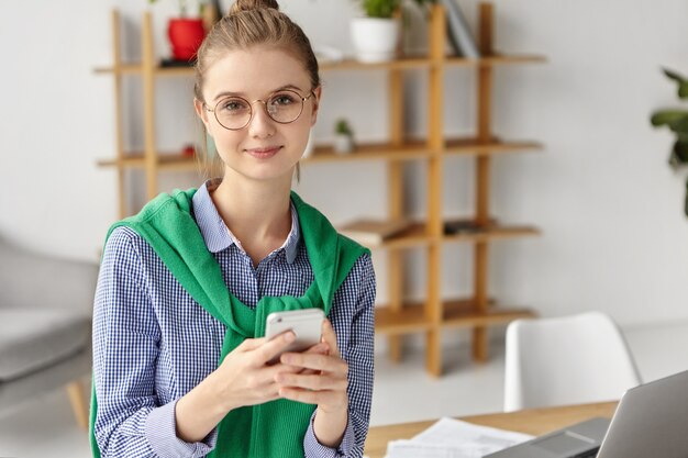 Beautiful woman dressed formally in office with phone