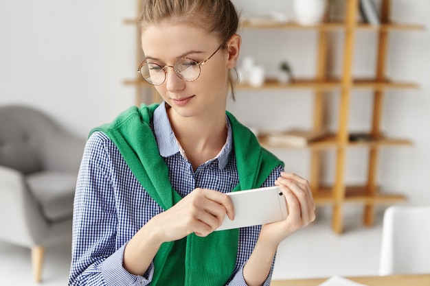 Beautiful woman dressed formally in office with phone