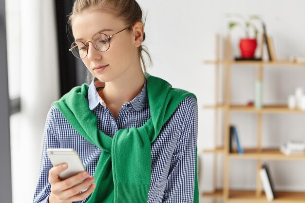 電話でオフィスで正式に服を着た美しい女性