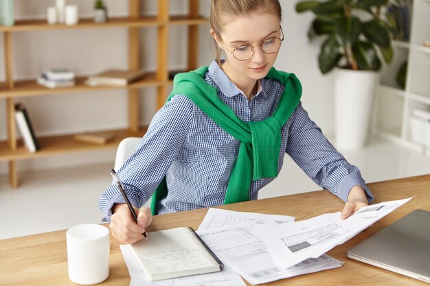 Beautiful woman dressed formally in office writing