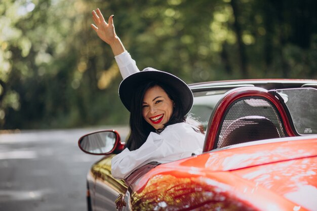 Beautiful woman driving red cabrio