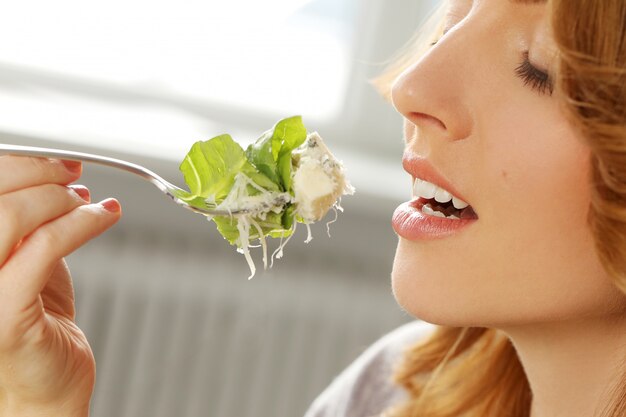 Beautiful woman eating in the office