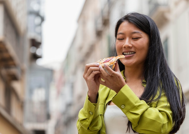 Beautiful woman eating street food outdoors