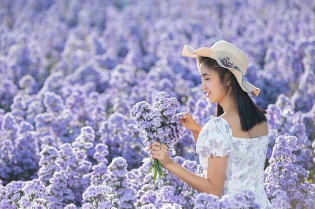 꽃 필드를 즐기는 아름 다운 여자