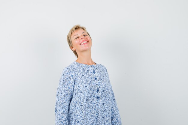 Beautiful woman feeling herself good in patterned blouse and looking blissful. .