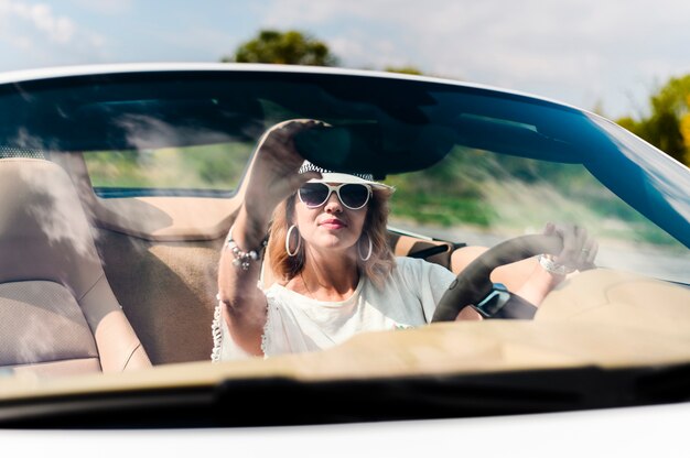 Beautiful woman fixing car mirror