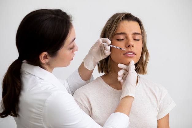 Beautiful woman getting lip filler medium shot