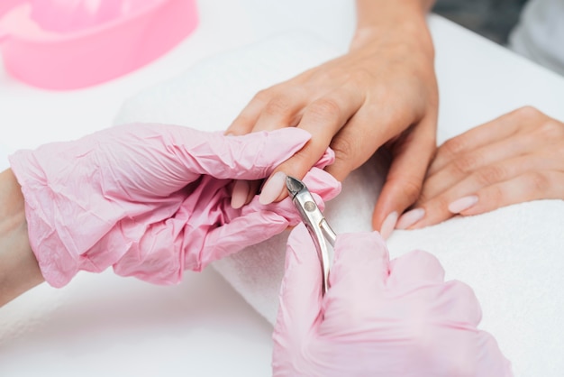 Beautiful woman hands cutting the cuticles