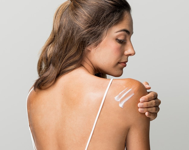 Beautiful woman having cream on her back