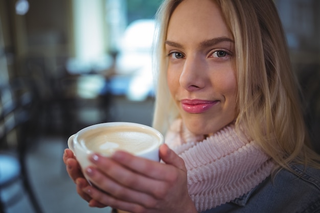 Beautiful woman having a cup of coffee in cafÃ©