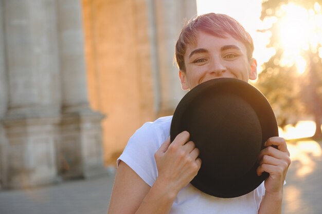 Beautiful woman hiding face behind hat showing eyes