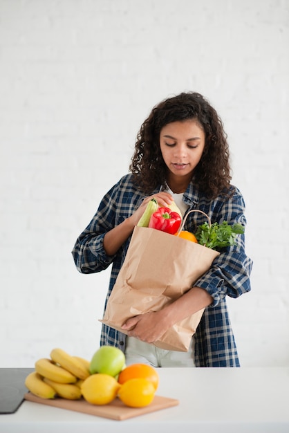 Beautiful woman holding bag of vegetables