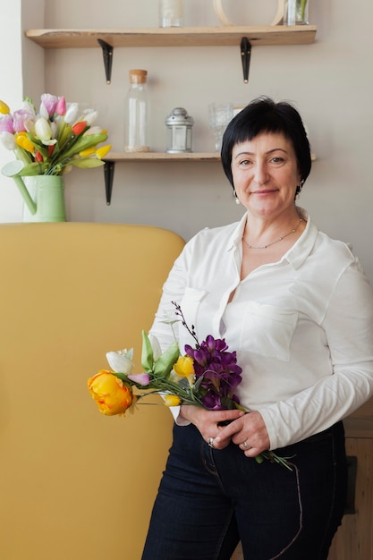 Free photo beautiful woman holding bouquet of flowers