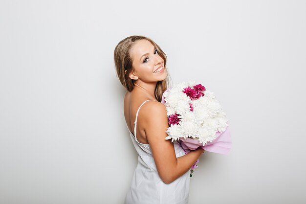 Beautiful woman holding bunch of flowers