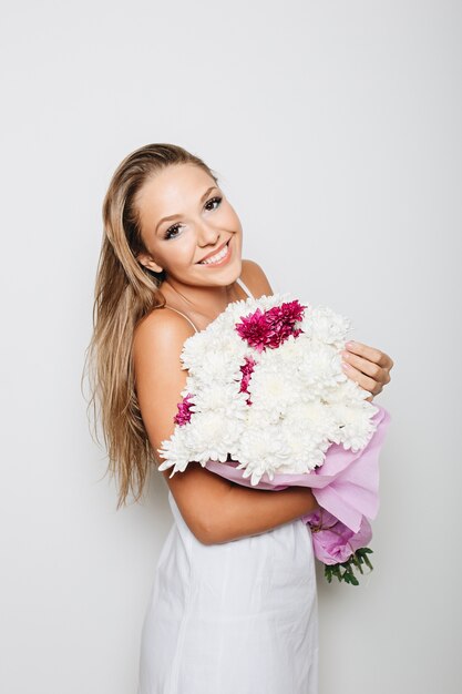 Beautiful woman holding bunch of flowers