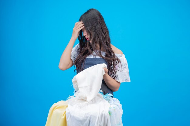 A beautiful woman holding a cloth prepared to wash on blue