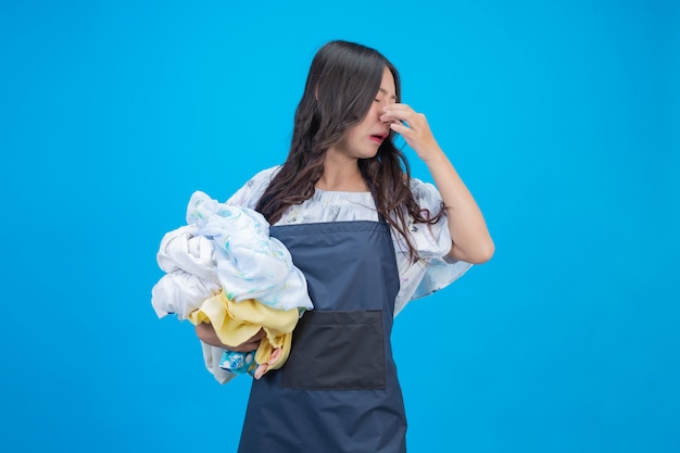 Una bella donna in possesso di un panno preparato per lavare sul blu