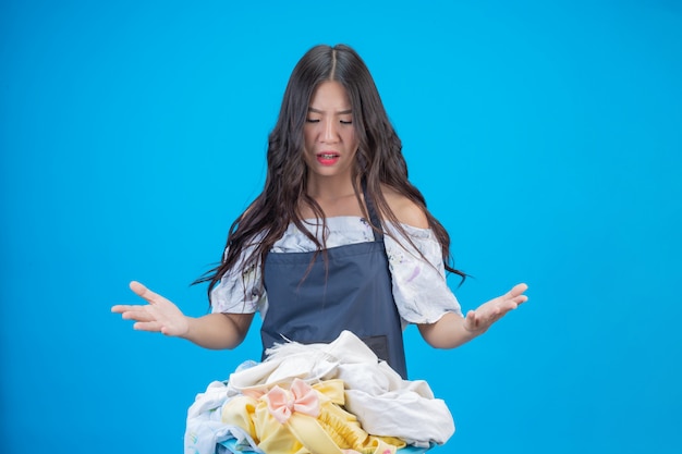 A beautiful woman holding a cloth prepared to wash on blue