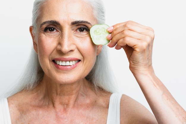 Beautiful woman holding cucumber slice