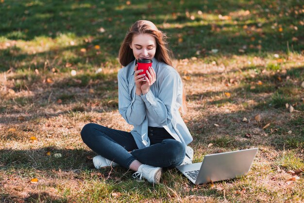 Beautiful  woman holding a cup in the nature