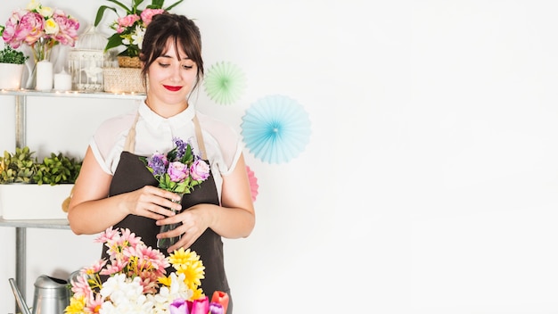 Beautiful woman holding fresh flower vase in floral shop