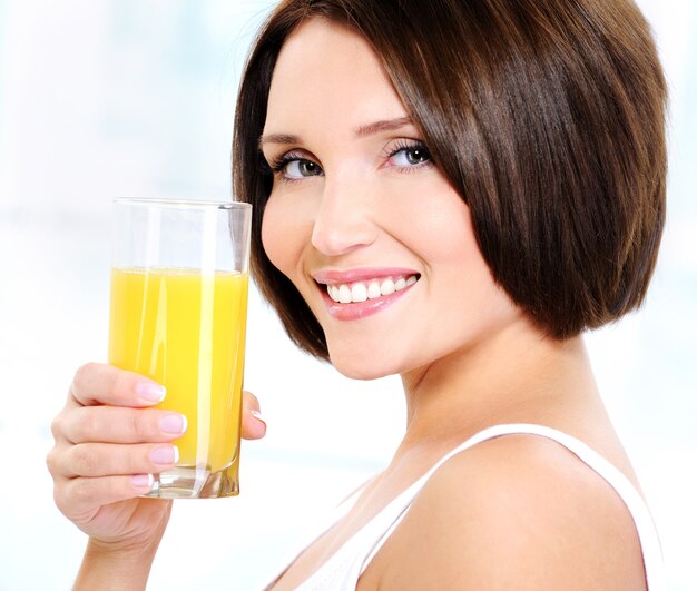 Free photo beautiful woman holding glass of orange juice