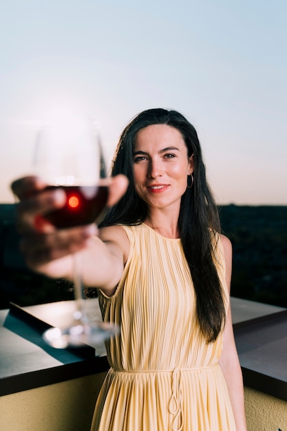 Beautiful woman holding glass of wine blurred foreground