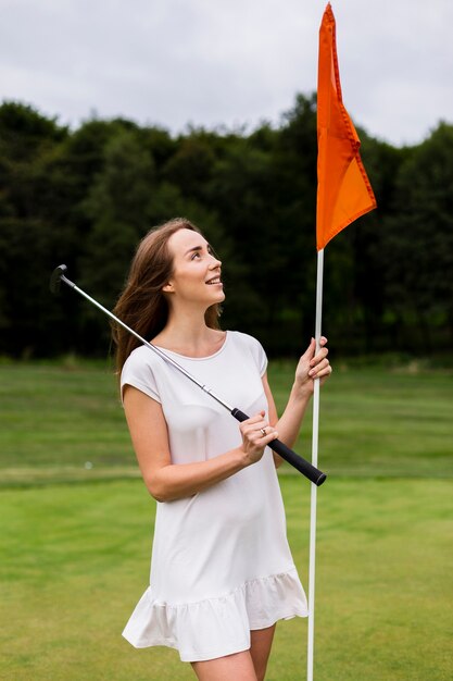 Beautiful woman holding golf pole