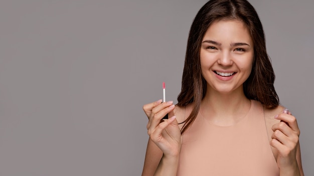 Beautiful woman holding a lipstick