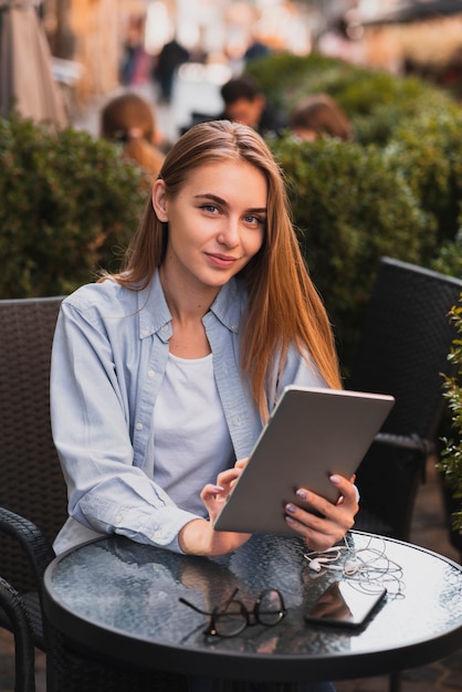 Free photo beautiful woman holding a tablet and looking on photographer