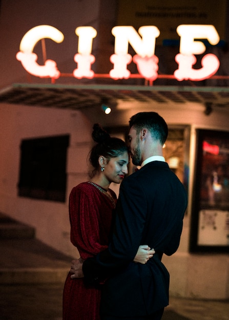 저녁에 거리에서 젊은 남자와 포옹하는 아름 다운 여자
