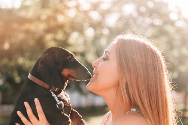 Beautiful woman kissing her cute dog