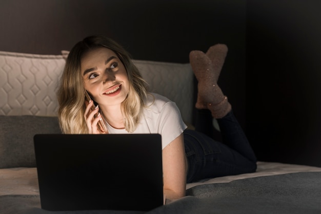 Beautiful woman laying in bad with laptop