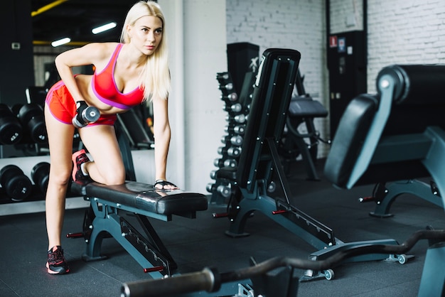 Free photo beautiful woman lifting small dumbbell