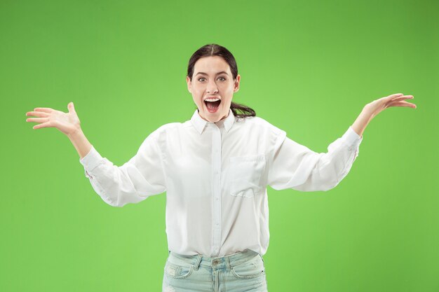 Beautiful woman looking suprised isolated on green