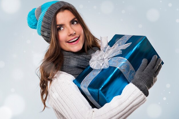Красивая женщина во время волшебного рождества с синим подарком