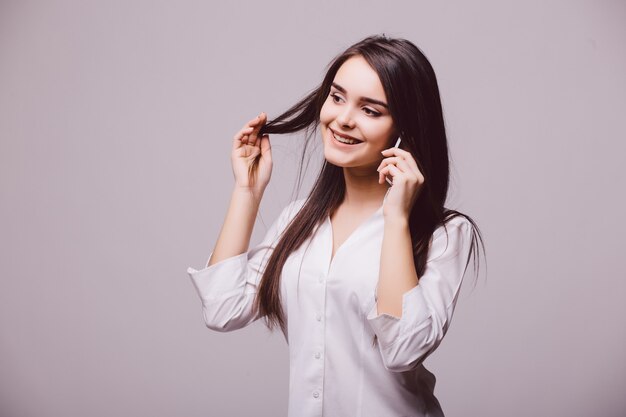 Beautiful woman making a phone call, isolated over white background