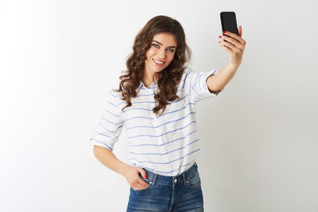 Beautiful woman making selfie photo on mobile phone, smiling, happy, islolated, curly hair, positive mood, , attractive model posing